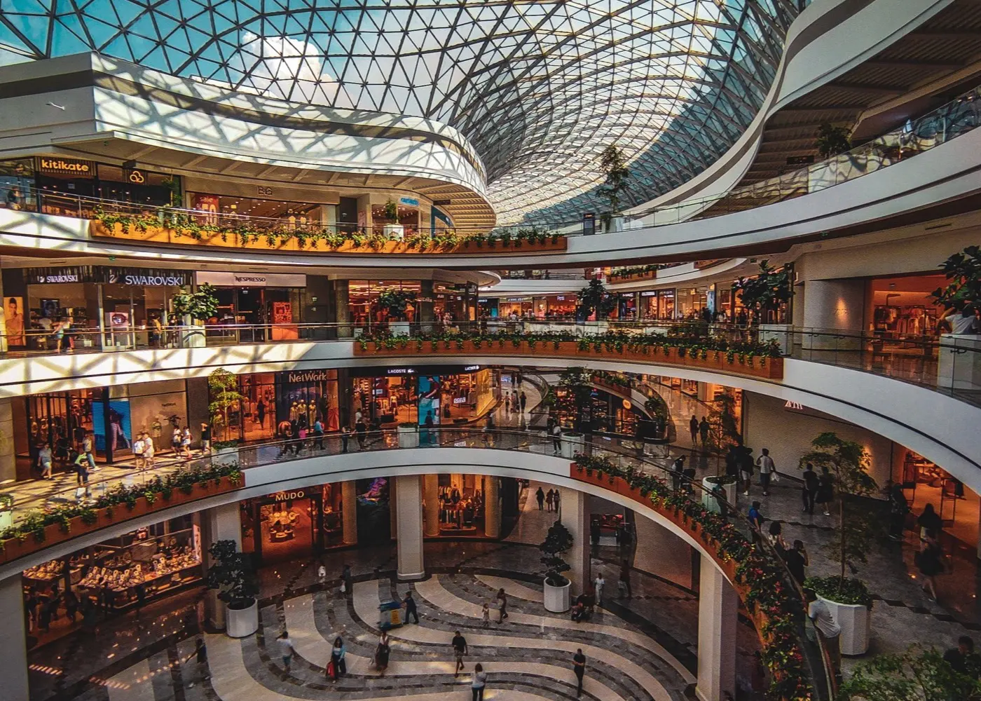 A multi-level shopping mall under a glass dome